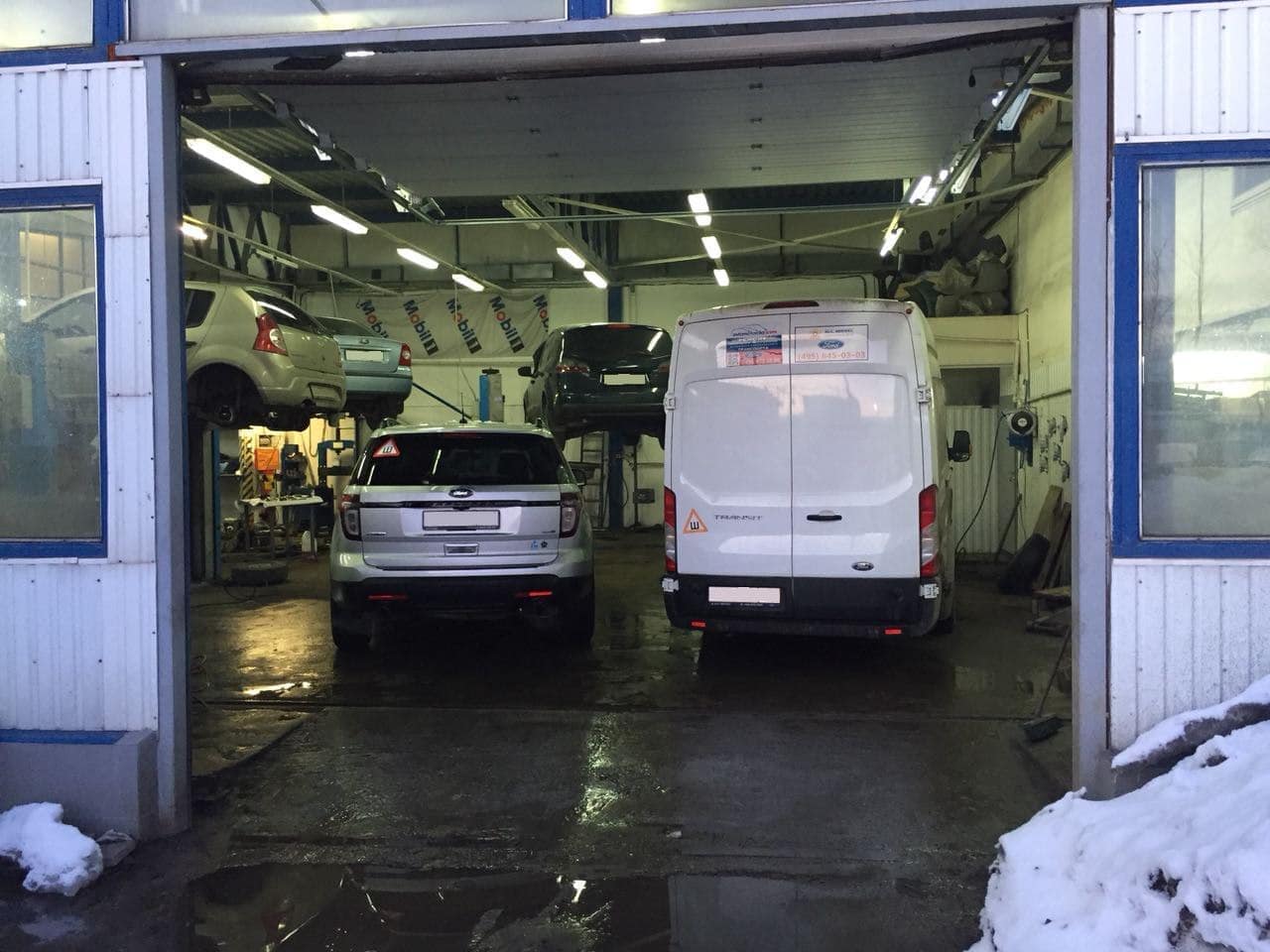 Two mechanics working together on a car engine.